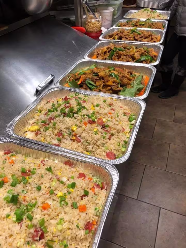 Row of fried rice and stir-fry catering trays